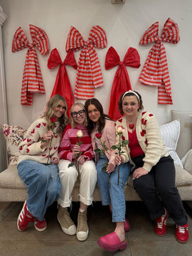 Layers Bedding Team at Galentines Event - four girls by photo wall at layers bedding 