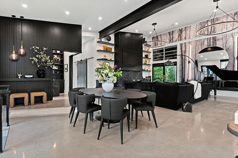 Down to Earth Projects | Park City Parade with Riverwood Interiors - modern kitchen in black with adjacent family room 