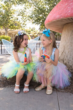 Woodland Fairy Festival  - two girls eating fairy bread under a mushroom 