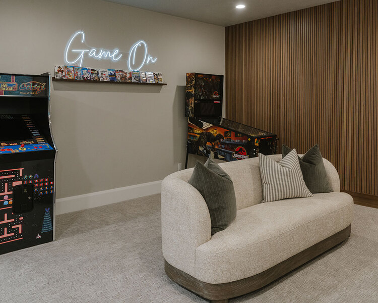 Down to Earth Projects | Utah Valley Parade at The Legacy at Meadow Ridge - Down to Earth Projects | Utah Valley Parade at The Legacy at Meadow Ridge - game room with pinball machine pac man video game and a sofa
